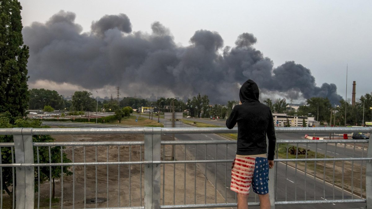 Una persona observa las nubes de humo que se elevan sobre la capital ucraniana tras un ataque nocturno en Kiev, Ucrania, este martes.