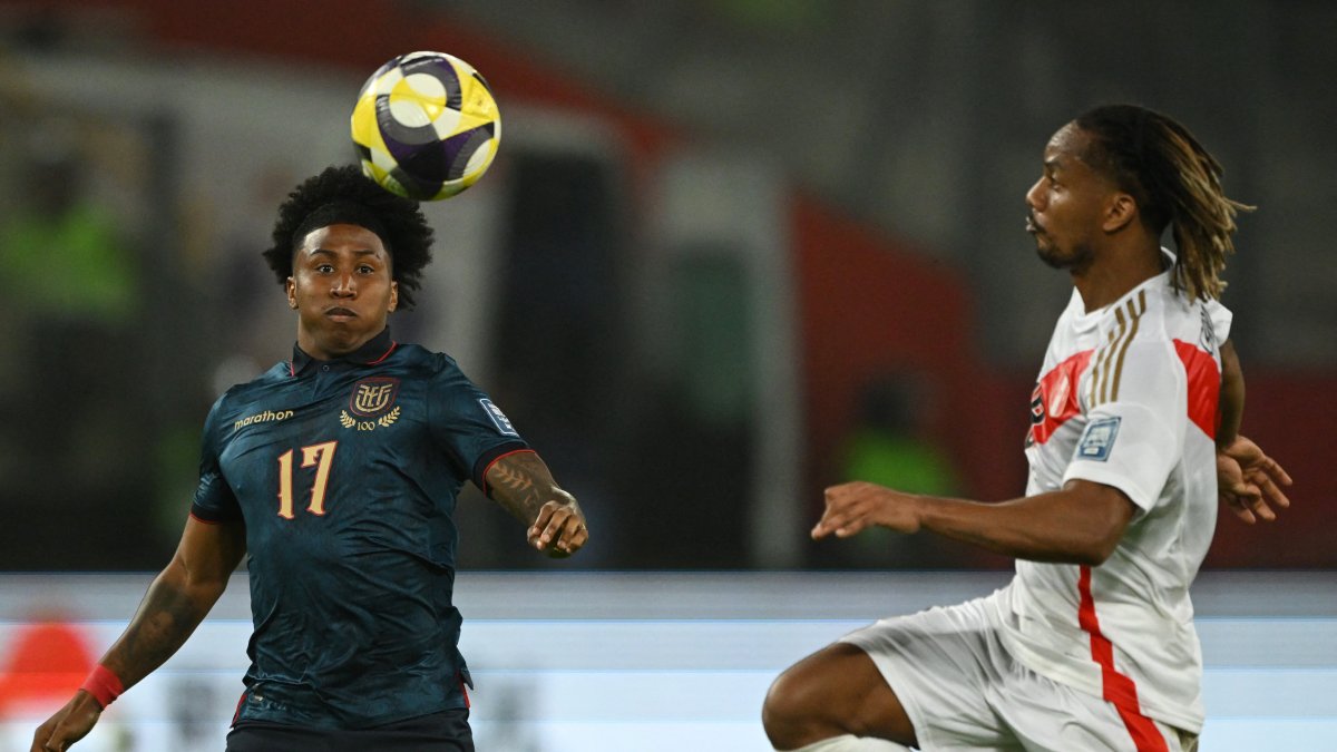 Angelo Preciado (i) disputa una pelota contra André Carrillo, de Perú