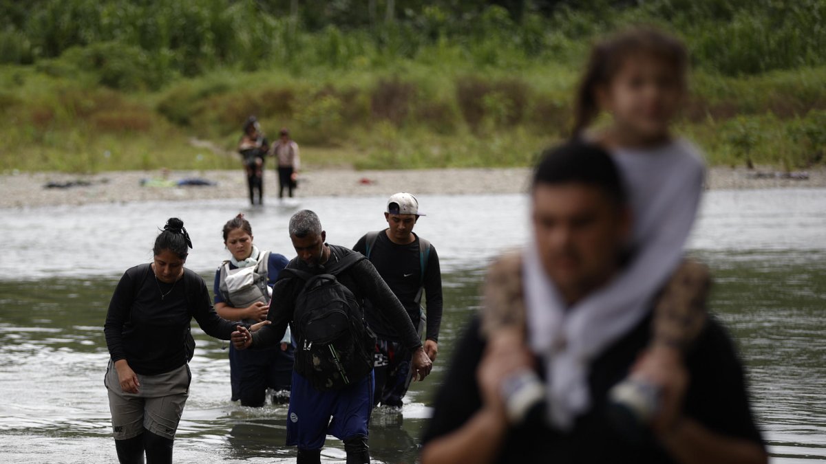 Migrantes que cruzan el río Tuquesa luego de atravesar la selva del Darién en el Darien (Panamá).