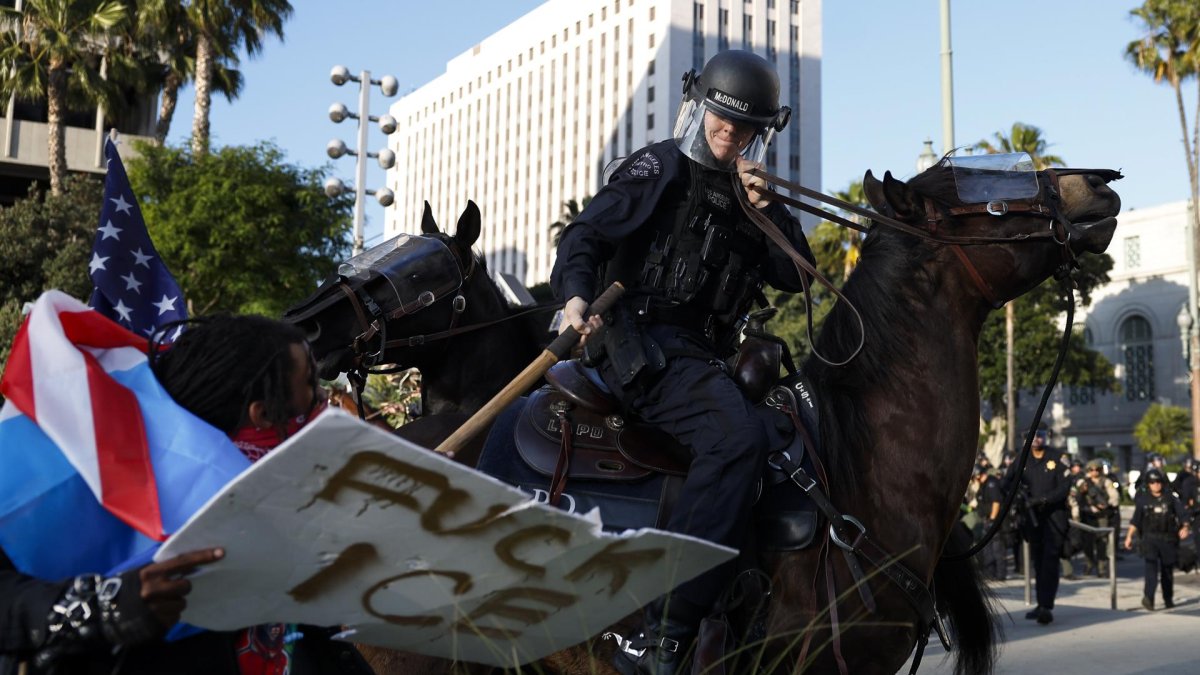 Agentes del Departamento de Policía de Los Ángeles se enfrentan a los manifestantes.