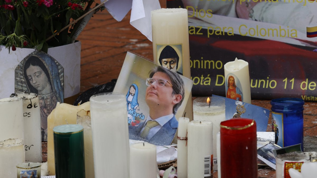 Fotografía de una imagen del senador Miguel Uribe en medio de velas puestas en un altar frente al hospital Fundación Santa Fe de Bogotá