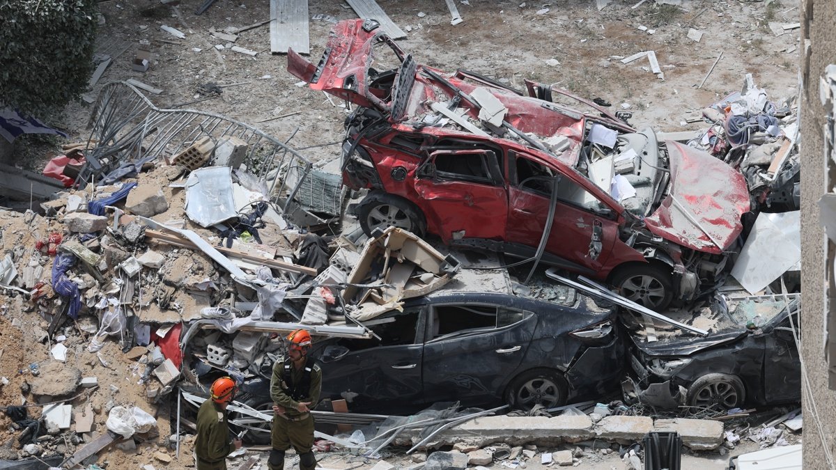 Equipos de rescate en la zona donde impactó en el centro de Israel un misil lanzado por Irán.
