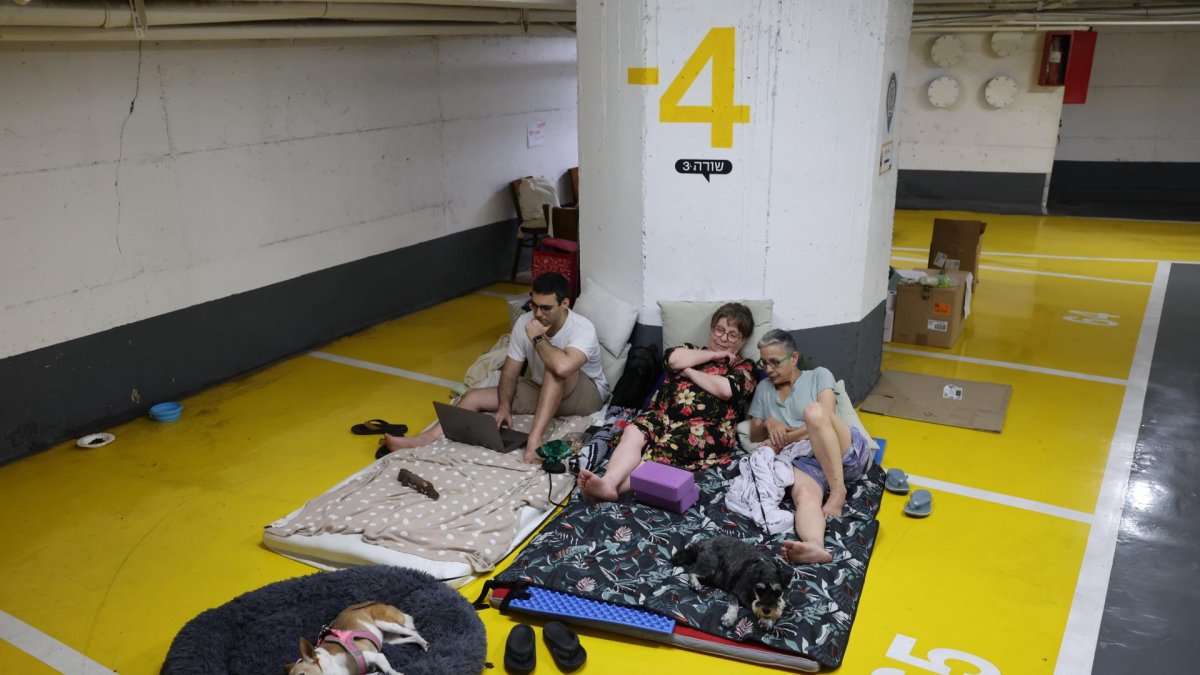 Personas pasan la noche en un estacionamiento subterráneo en medio de las amenazas de ataques con misiles balísticos iraníes, en Tel Aviv, Israel, el 17 de junio de 2025.