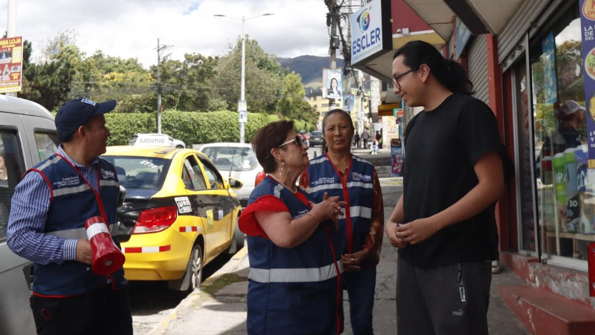 Edgar Vaca, Teresa Sarmiento y detrás Martha Manya, del comité de seguridad de San José de Jarrín Alto de Cotocollao, en el norte de Quito. Informan a vecinos sobre una minga.