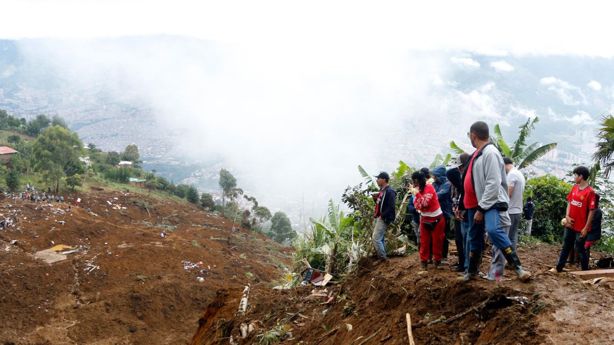 Personas observan la zona afectada por una riada el martes 24 de junio de 2025, en Bello (Colombia).