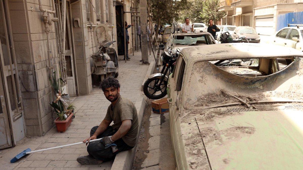 Un hombre iraní descansa mientras retira los escombros de su casa dañada después de un reciente ataque aéreo en Teherán, Irán.