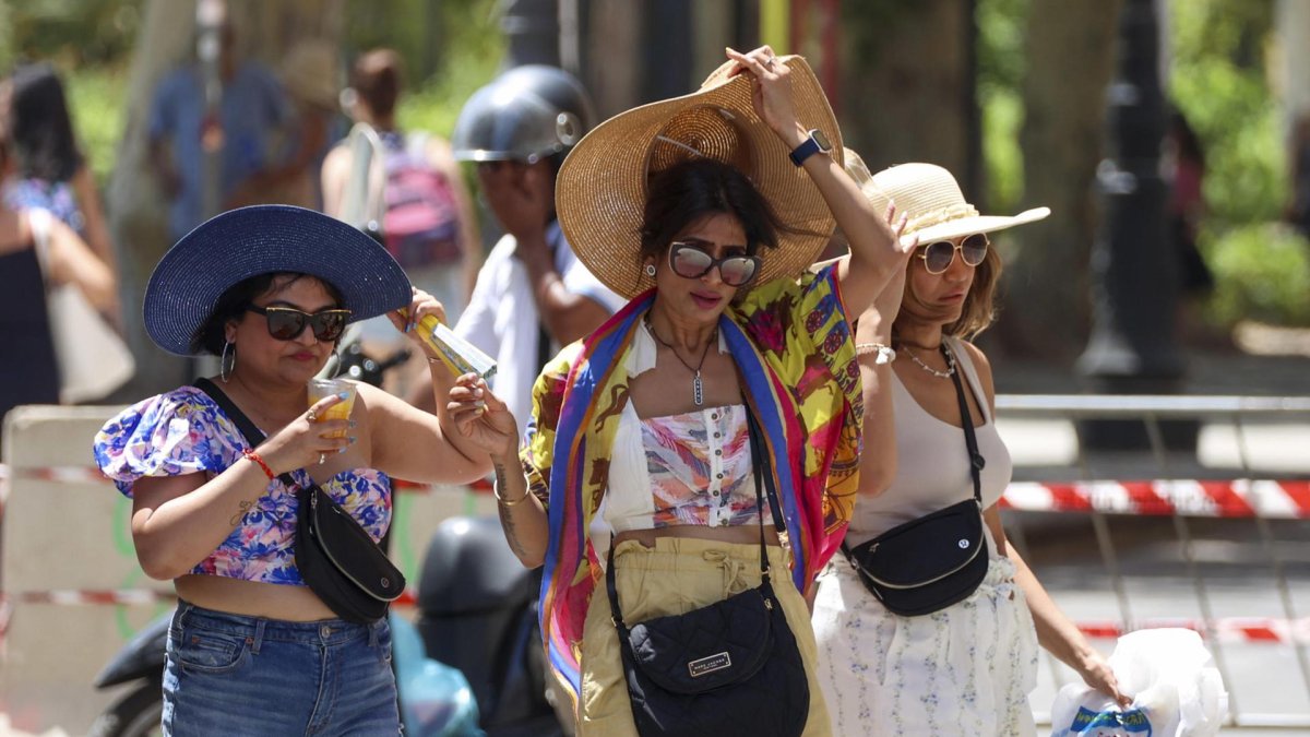 Varias mujeres caminan durante una ola de calor en Palermo, Sicilia (Italia).