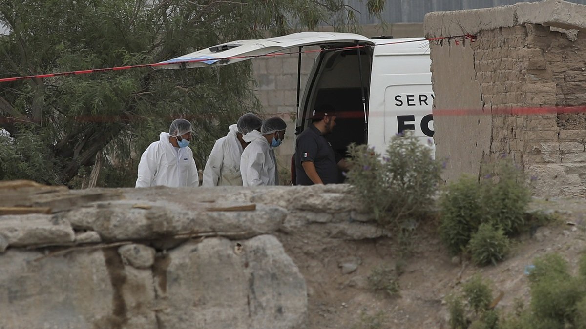 Autoridades estatales y personal médico forense trabajaron en un inmueble donde fueron hallados 60 cuerpos embalsamados, este viernes 27 de junio en Ciudad Juárez.