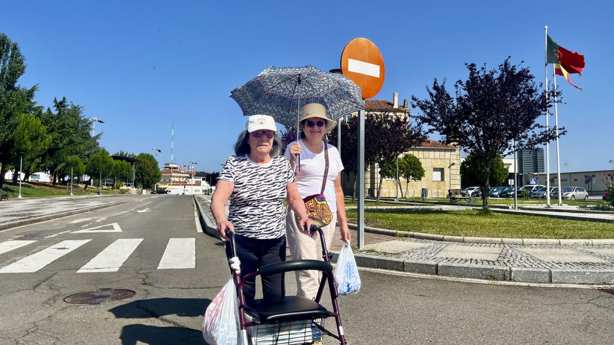 Dos mujeres pasean con el paraguas en la localidad portuguesa de Vilar Formoso (Portugal), para protegerse del sol.