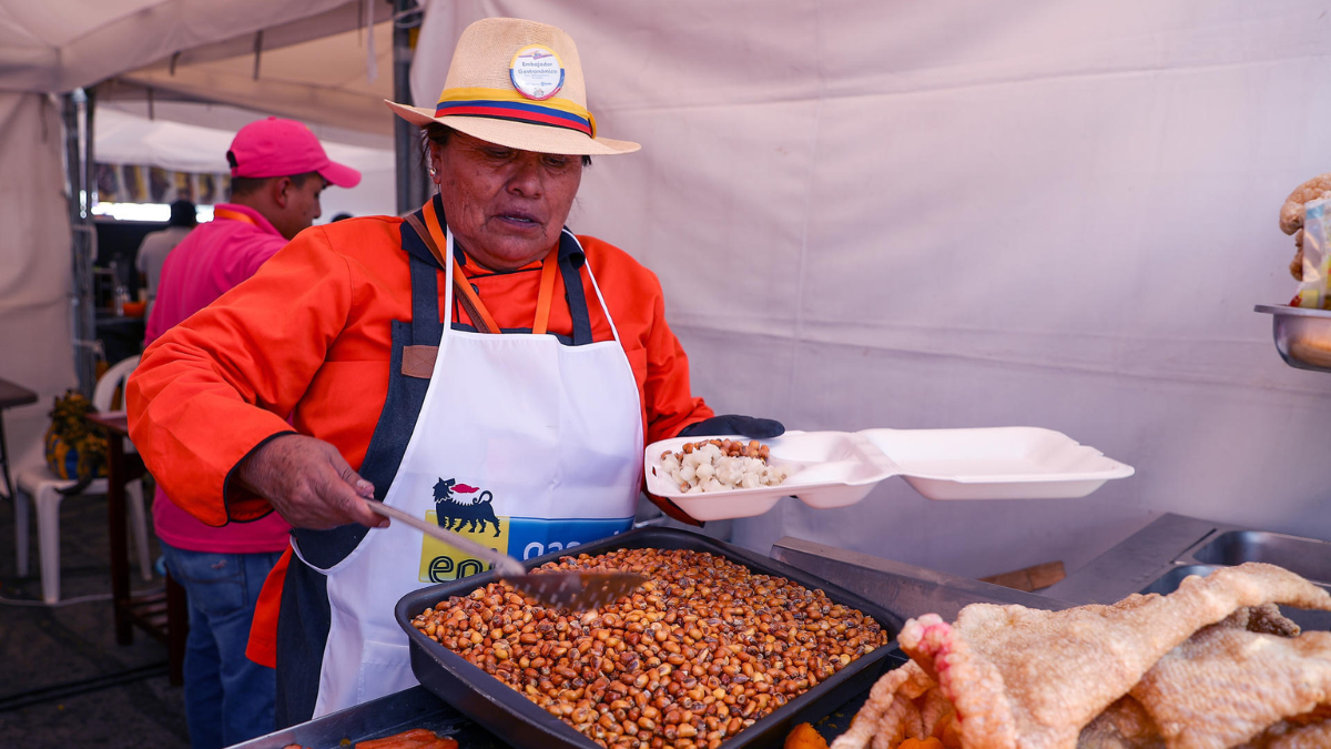 Fotografía de archivo fechada el 09 de agosto de 2024 de una mujer sirviendo alimentos típicos en Quito (Ecuador).