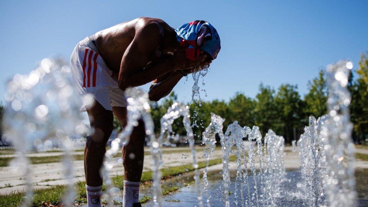 Un peatón en una fuente pública se vierte agua en la cara en un día caluroso en Berlín, Alemania, este miércoles 2 de julio de 2025.