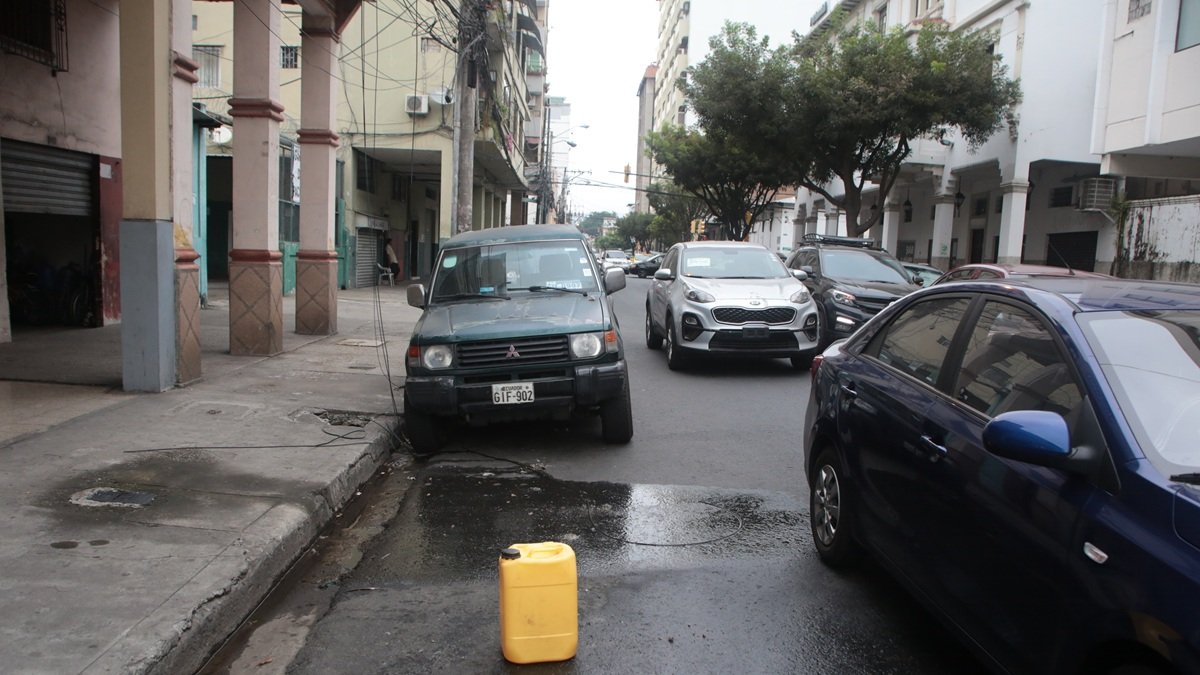 En varias zonas del centro de Guayaquil, los ‘cuidadores’ de carros utilizan envases plásticos para separar los espacios en la vía pública. La actividad sigue sin control.