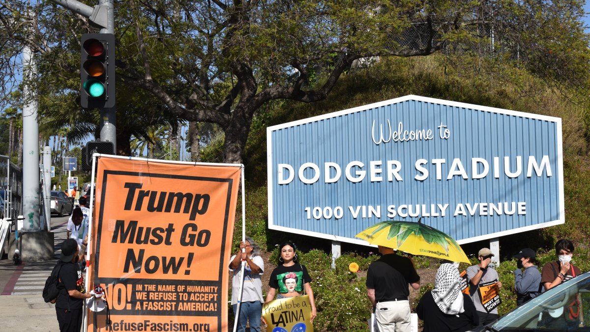 Fotografía de archivo del 20 de junio de 2025 de personas protestando contra las políticas migratorias con una pancarta que dice 'Trump debe irse ahora'.