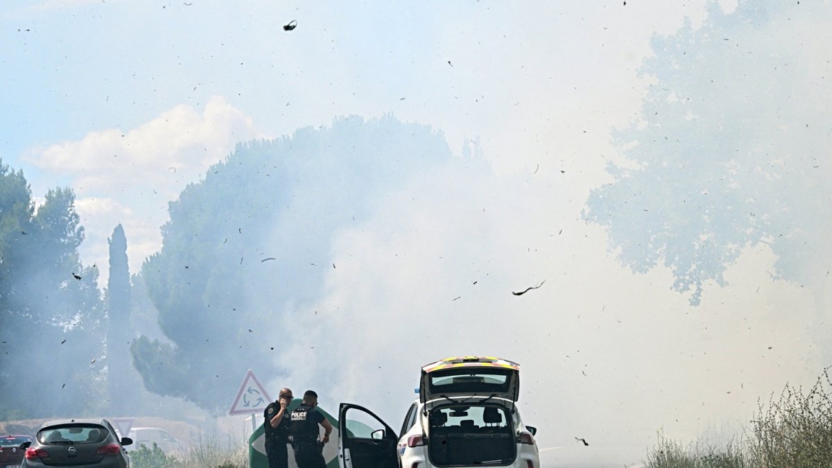 Agentes de policía cierran la carretera cuando se desató un incendio forestal en el sur de Francia, el 7 de julio de 2025.