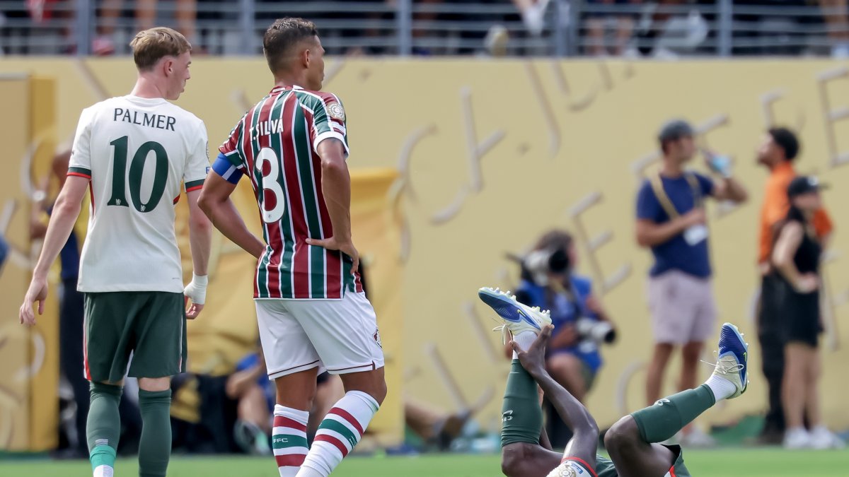 Moisés Caicedo (d) se sujeta el pie izquierdo tras caer ante Thiago Silva (C) durante el partido de la Copa Mundial de Clubes entre el Fluminense y Chelsea.