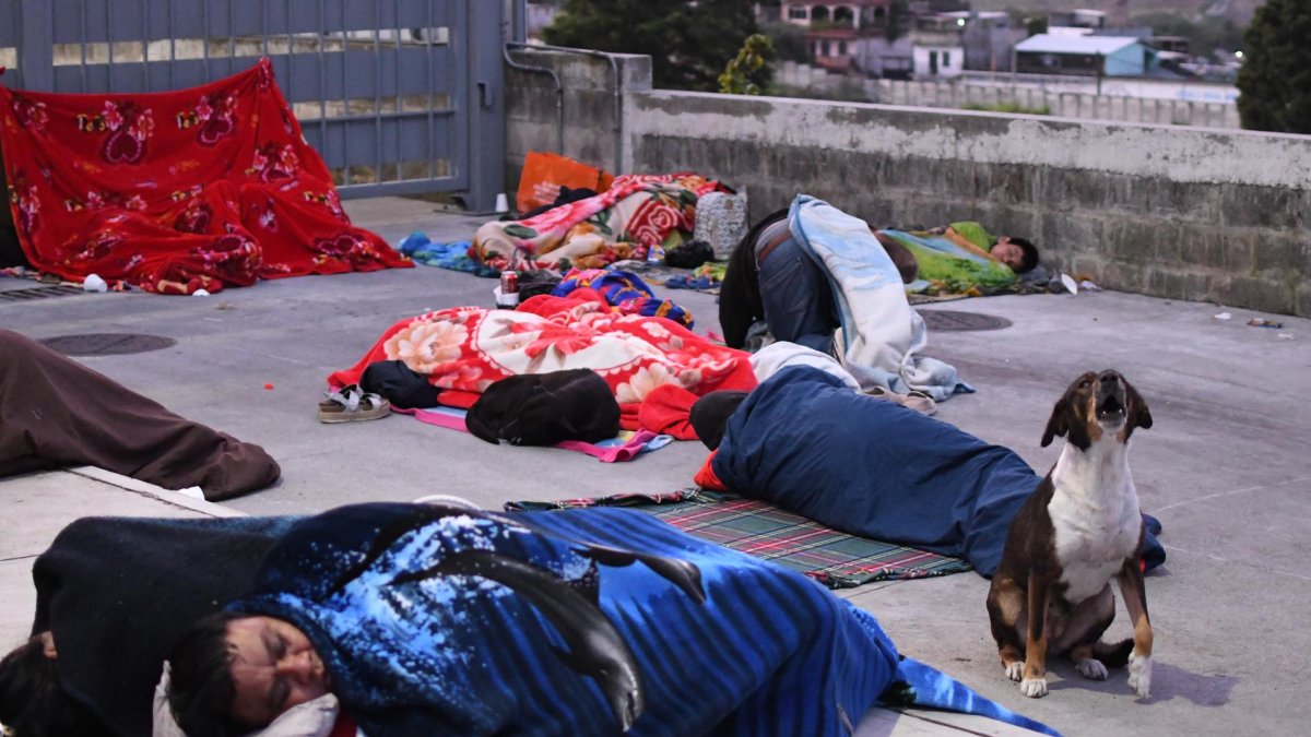 Personas duermen en una calle tras los fuertes temblores el 9 de julio de 2025, en Palín (Guatemala).