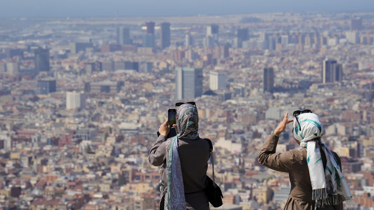 Turistas en el Turó de la Rovira de Barcelona en junio de 2025, en medio de la ola de calor.