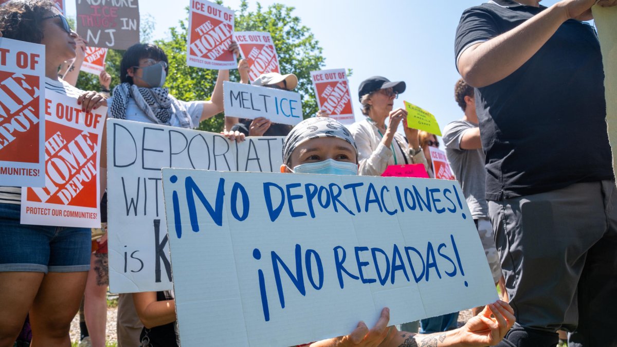 Personas sostienen carteles durante una manifestación por las recientes redadas de ICE en East Windsor, New Jersey (Estados Unidos).