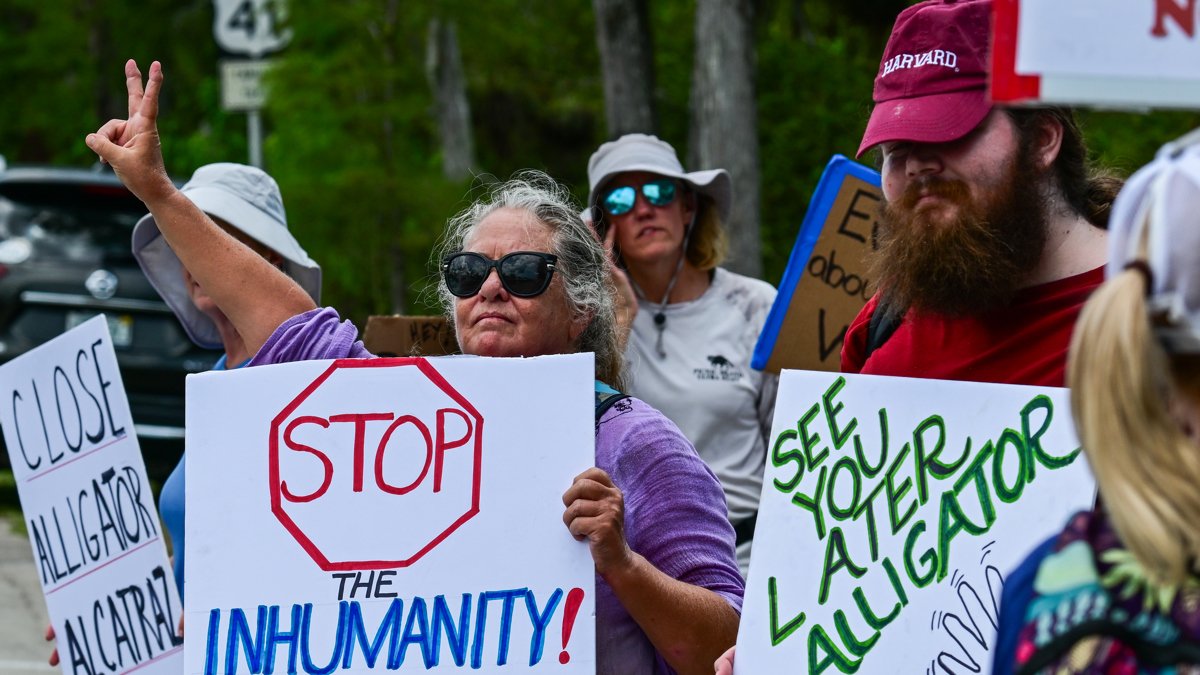 Personas sostienen carteles durante una manifestación este sábado 12 de julio, frente el centro de detención de migrantes 'Alligator Alcatraz' en Ochopee, Estados Unidos.