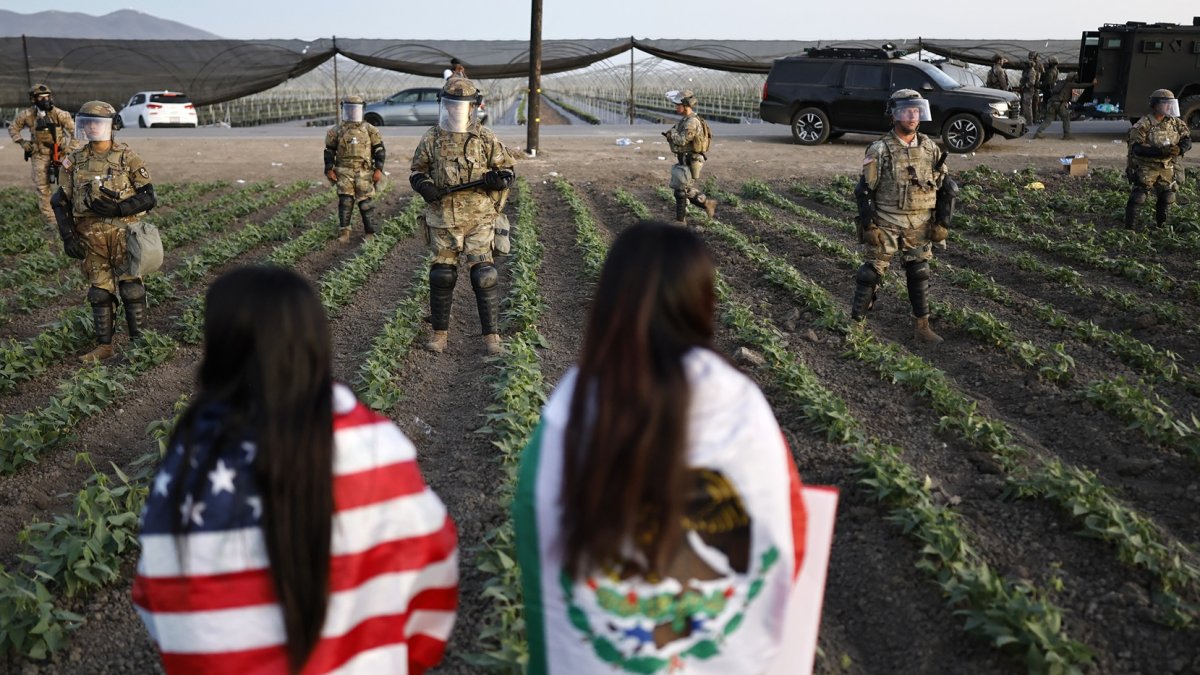 Soldados de la Guardia Nacional bloquean a los manifestantes durante una redada de inmigración de ICE en una granja de cannabis cercana el 10 de julio de 2025 cerca de Camarillo, California.