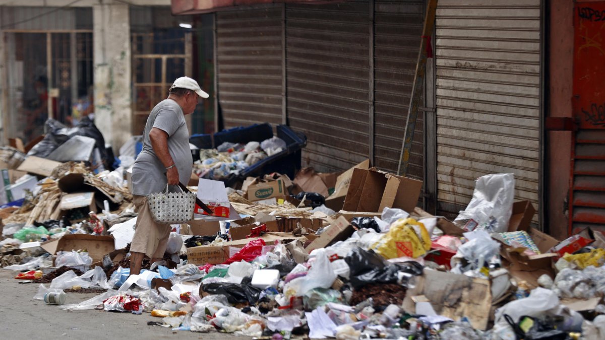 Una persona camina buscando cosas en la basura acumulada en una calle este 17 de julio de 2025, en La Habana (Cuba).