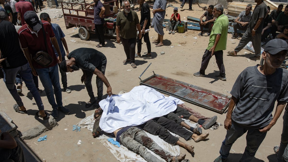 Palestinos lloran sobre los cuerpos de los acribillados.