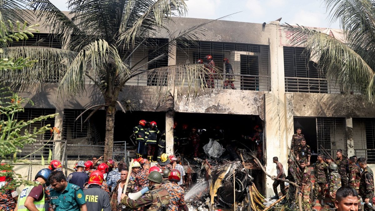 El servicio de bomberos y el personal de seguridad de Bangladés realizan búsqueda y rescate después de que un avión de la Fuerza Aérea se estrellara contra una escuela en Daca el 21 de julio de 2025.