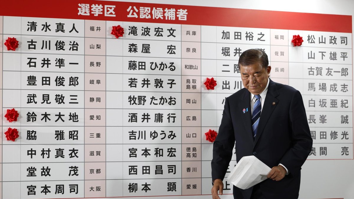 Shigeru Ishiba, primer ministro de Japón y presidente del gobernante Partido Liberal Democrático (PLD), camina junto a un tablero con rosas de papel rojas que muestran a los candidatos electos.