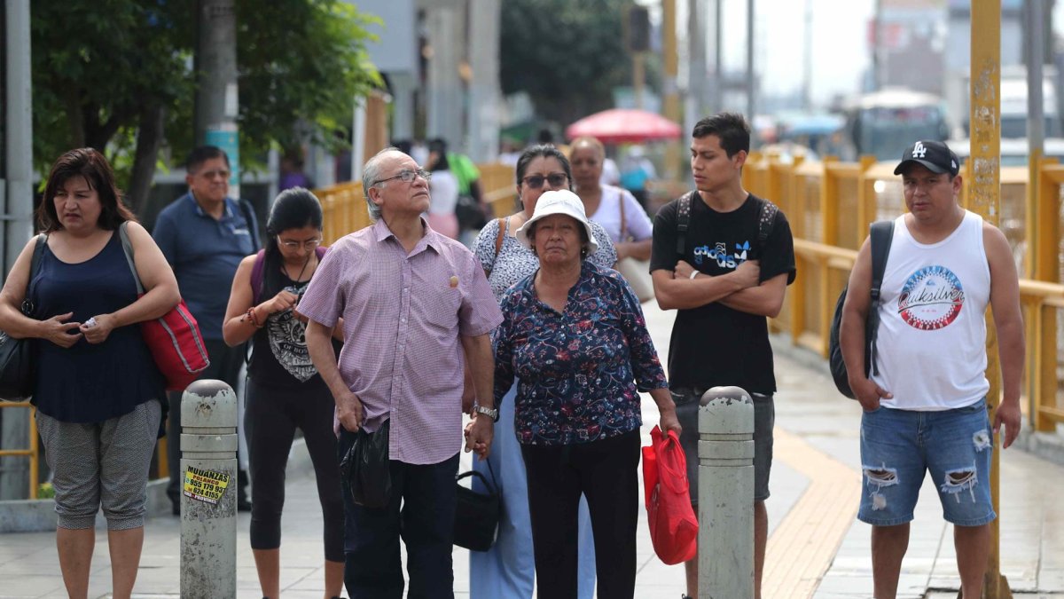 Un grupo de transeúntes al esperar cruzar una calle de Lima (Perú).