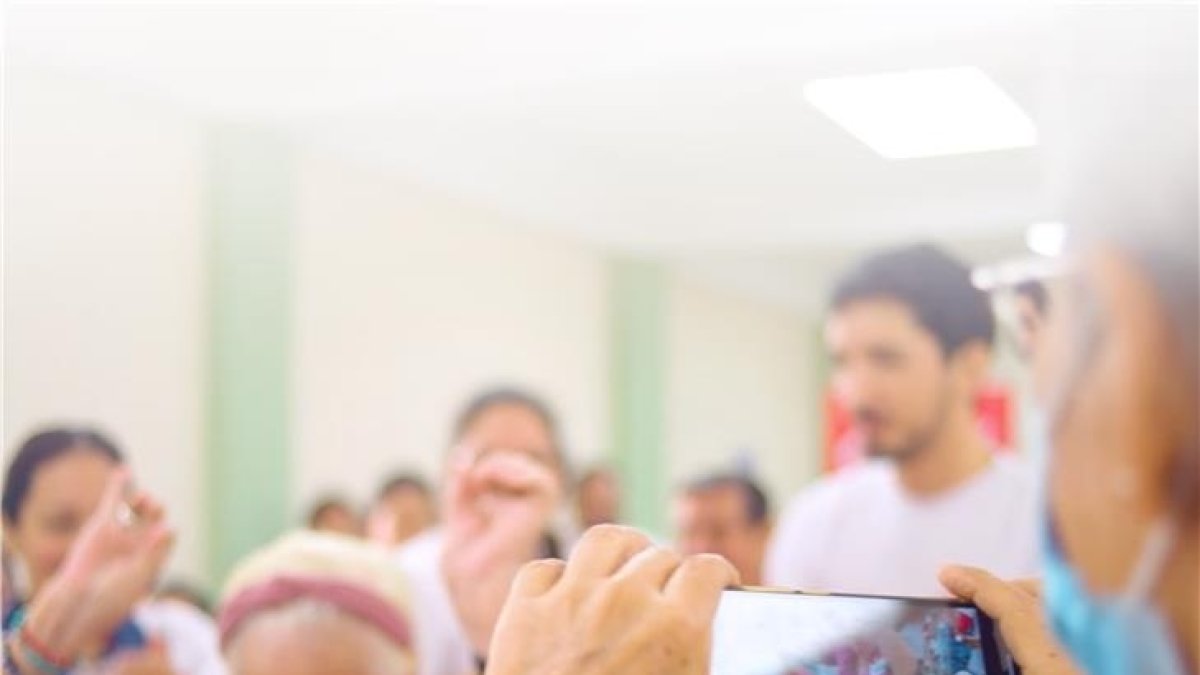 Adultos mayores aprenden a usar la tecnología que tiene un celular.