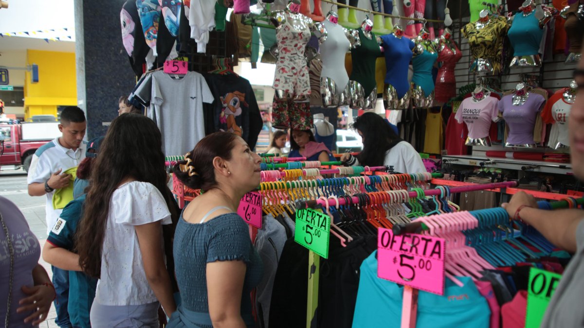 Clientes miran ropa en una tienda en el centro de Guayaquil.