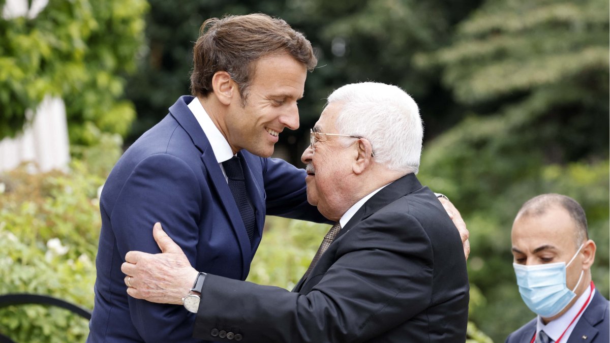 El presidente francés, Emmanuel Macron (izq.), da la bienvenida al presidente palestino Mahmoud Abbas antes de una reunión en el Palacio Presidencial del Elíseo en París el 20 de julio de 2022.