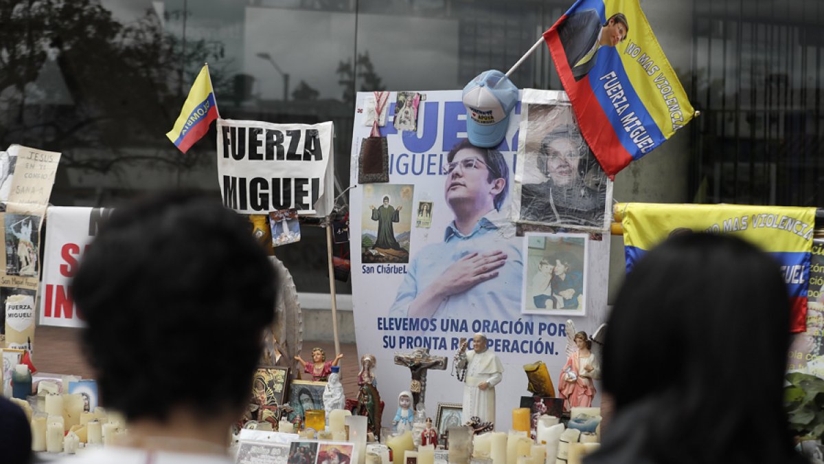 Personas oran en un altar improvisado frente a la Fundación Santa Fe, lugar donde permanece hospitalizado el senador colombiano Miguel Uribe Turbay.