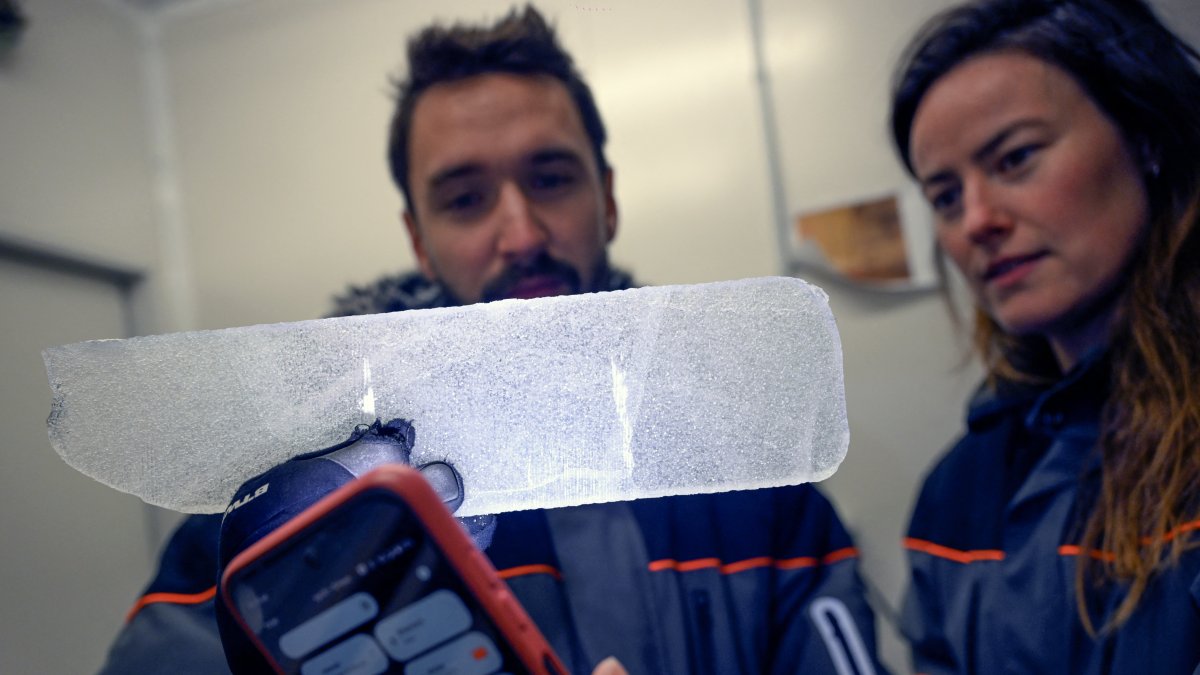 Hielo. Científicos retroiluminan una muestra de hielo azul en el laboratorio.