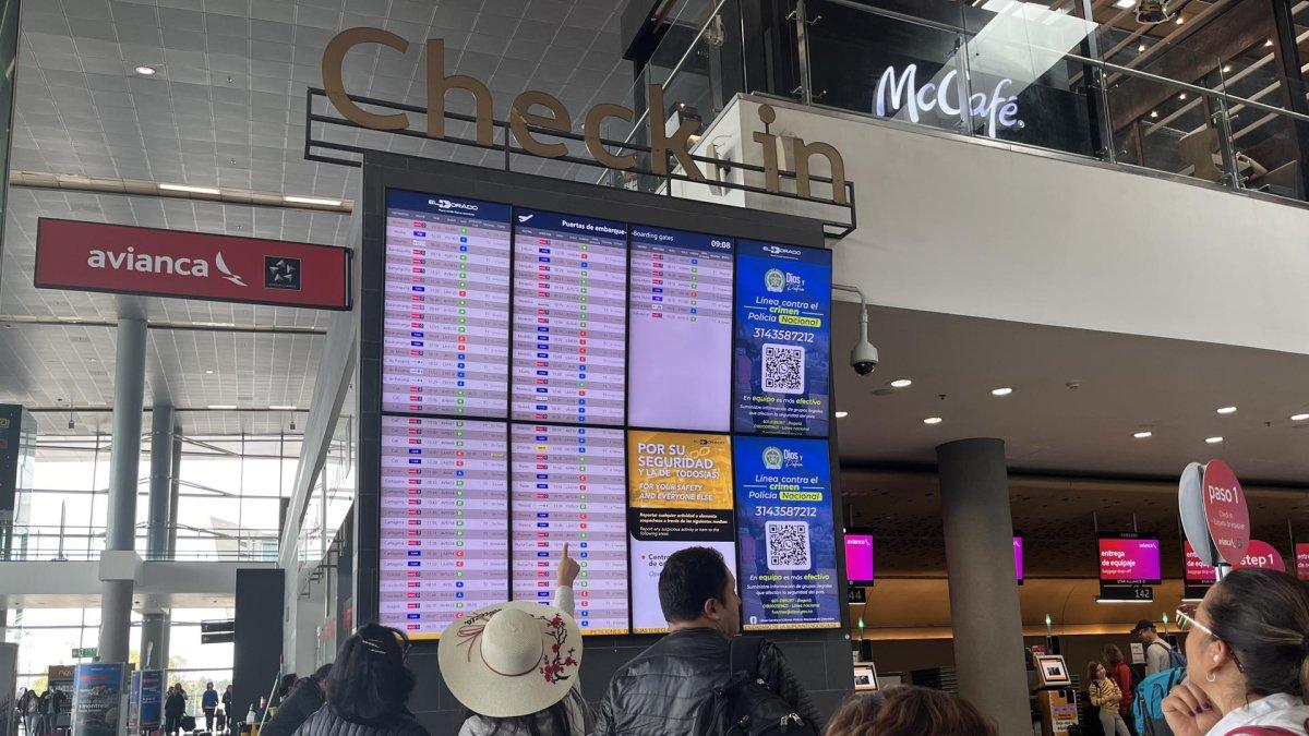 Viajeros observan los itinerarios de sus vuelos en el Aeropuerto El Dorado en Bogotá (Colombia), en una fotografía de archivo.