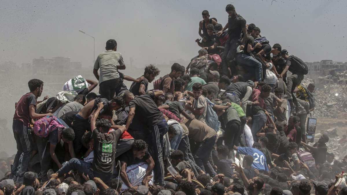 Palestinos intentan conseguir sacos de harina de un camión de ayuda en Zikim, al norte de la Franja de Gaza,