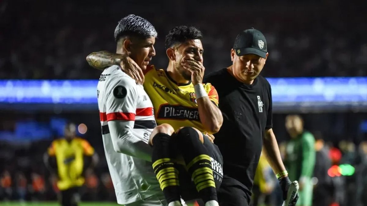 Un jugador de Sao Paulo lleva en sus brazos a Joao Rojas, tras su lesión en el partido ante Barcelona en Copa Libertadores.