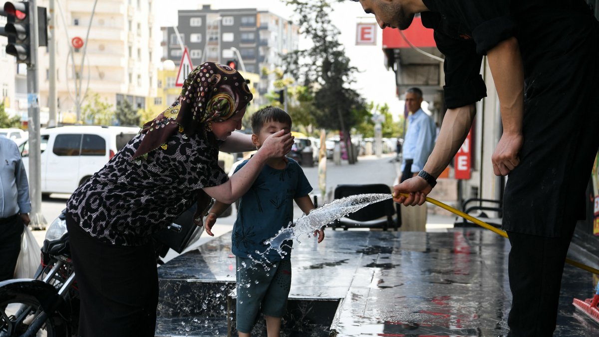 Calor. Las personas pausan su paso para refrescarse con agua en la calle.
