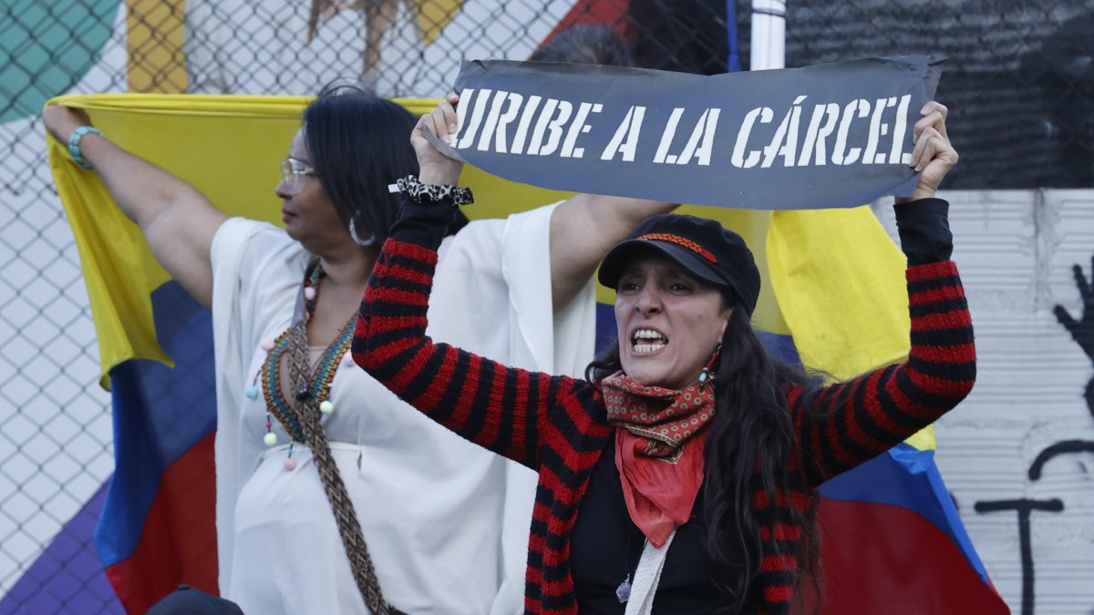 Una detractora del expresidente de Colombia, Álvaro Uribe, sostiene un cartel frente al Complejo Judicial de Paloquemao este lunes, en Bogotá.