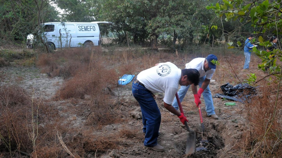 Empleados forenses que desentierran cuerpos de personas halladas en una fosa clandestina en Guanajuato (México).