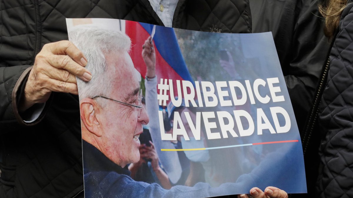 Una persona que sostiene un cartel en apoyo al expresidente colombiano Álvaro Uribe, condenado a doce años de cárcel.