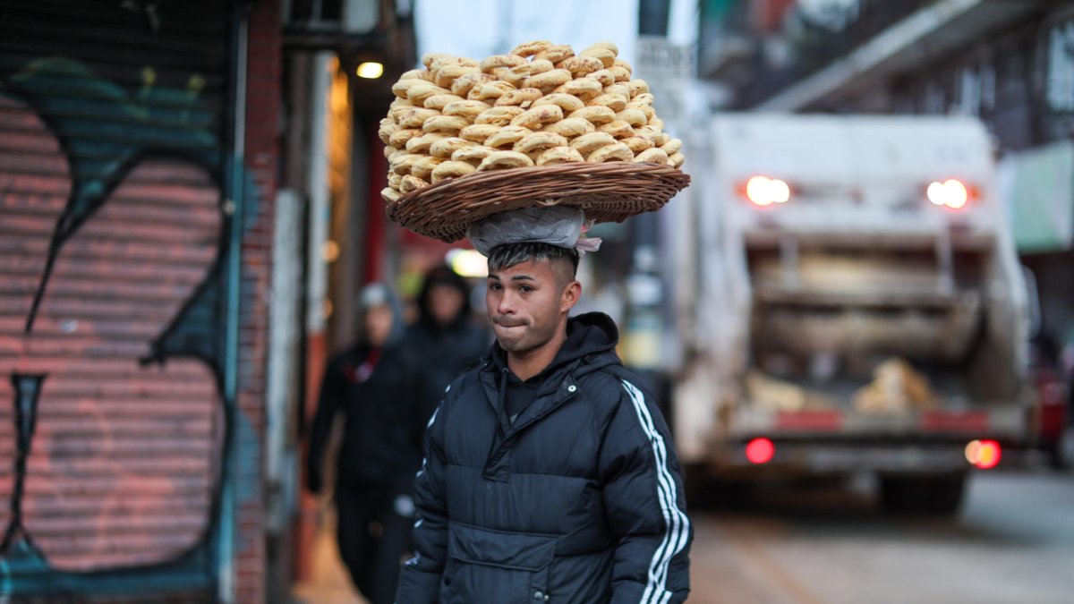Un hombre vende alimentos que sostiene en su cabeza este jueves 7 de agosto de 2025, en Buenos Aires (Argentina).