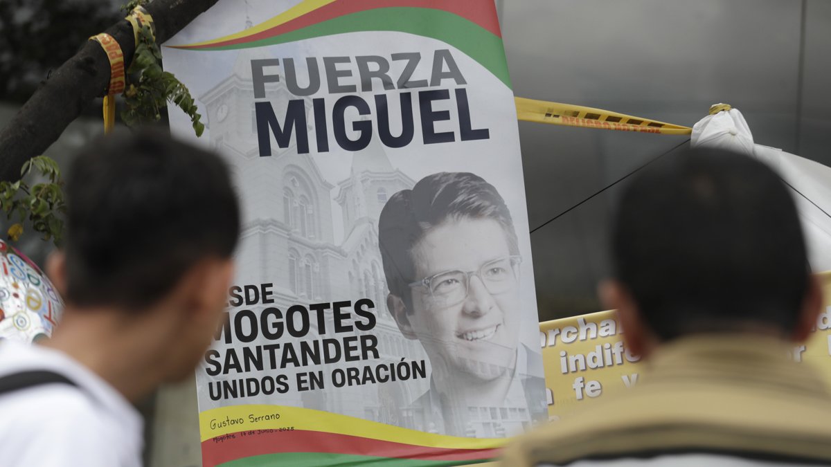 Fotografía de personas orando en un altar improvisado frente a la Fundación Santa Fe, lugar donde permanece hospitalizado el senador colombiano Miguel Uribe Turbay.