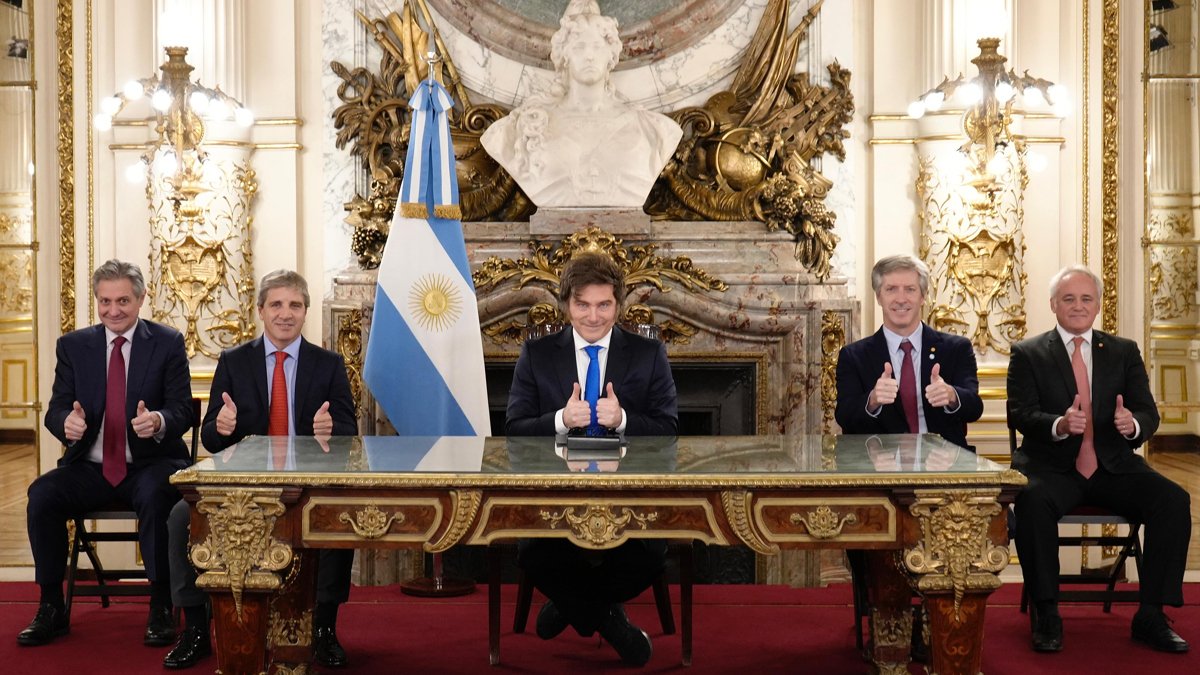 Fotografía cedida por la Presidencia de Argentina de su mandatario, Javier Milei (c), saludando junto a algunos de sus ministros durante una alocución este viernes, en Buenos Aires.