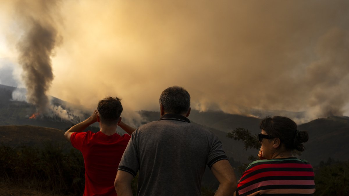Vecinos de Maceda (Ourense) observan el incendio que se registra en los alrededores de su municipio este domingo 10 de agosto.