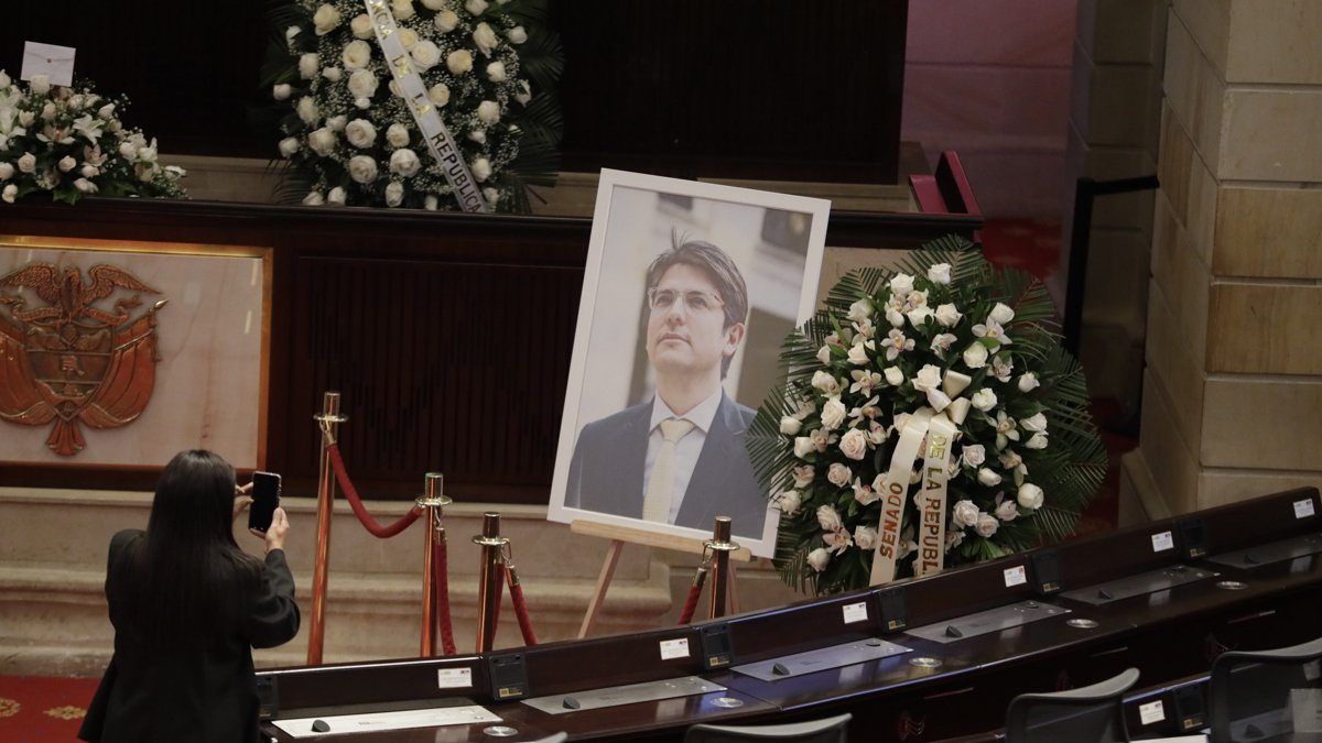 Una persona toma una fotografía a una imagen del fallecido senador y precandidato presidencial de Colombia, Miguel Uribe Turbay, este lunes 11 de agosto, en Bogotá.