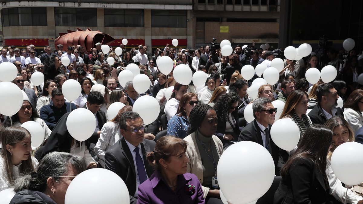 Personas sostienen globos durante un homenaje al fallecido precandidato presidencial de Colombia, Miguel Uribe, este lunes en la Procuraduría General de la Nación, en Bogotá.