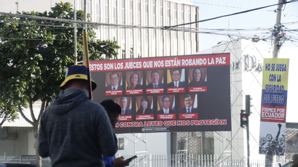 Vallas con los rostros de los nueve jueces de la Corte Constitucional aparecieron este 12 de agosto de 2025 en la ruta de la marcha convocada por el presidente Daniel Noboa.