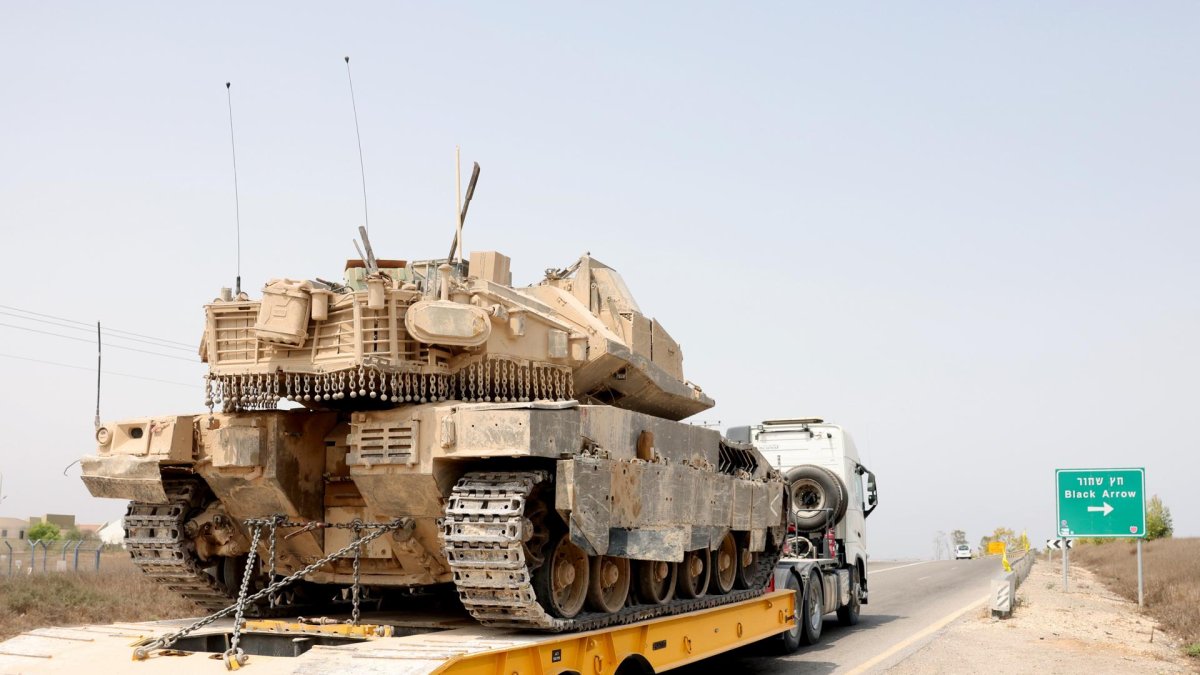 Un camión transporta un tanque israelí cerca de la frontera con la Franja de Gaza, visto desde el lado israelí, en el sur de Israel, el 12 de agosto de 2025.