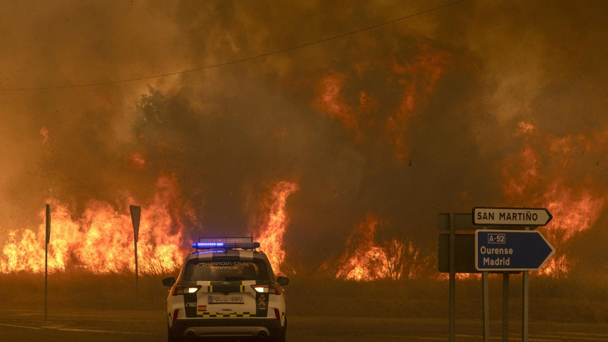 Vecinos y bomberos intentan aplacar el fuego que afecta este viernes a la aldea de Lamas (Cualedro), en Ourense